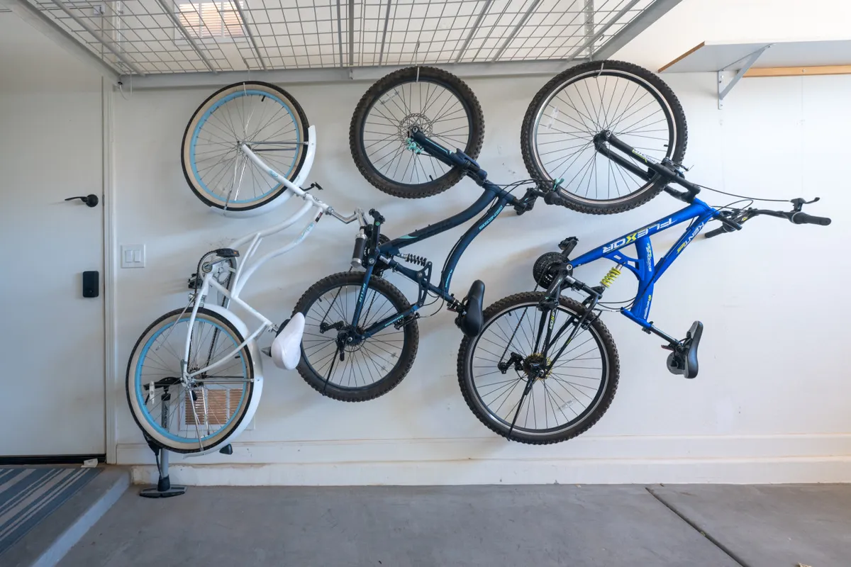 An interior storage area featuring four bicycles mounted on the wall, organized for easy access. The scene highlights an active lifestyle and readiness for family bike rides or outings to nearby parks.