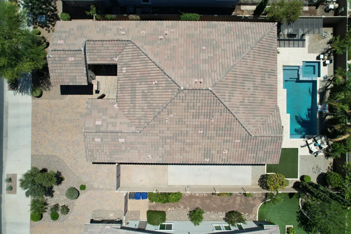 A serene backyard with a sparkling swimming pool, landscaped yard, and a cozy patio area. The setting is perfect for lounging, swimming, or gathering for outdoor meals and evening socials.